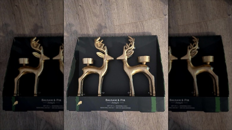 Two Balsam & Fir brass reindeer candleholders in their package on a table