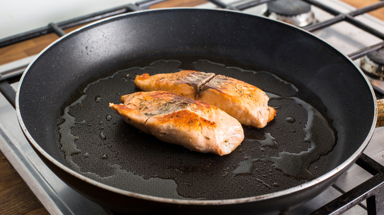 cooking salmon filets in pan with oil