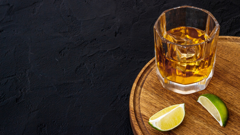 Whiskey glass and lime wedges