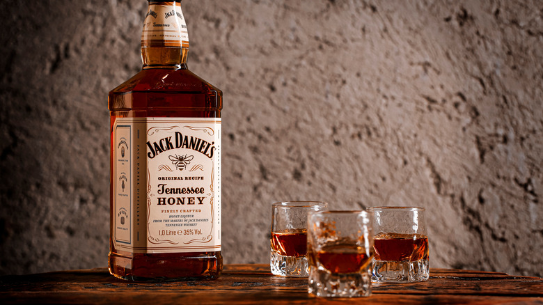 Bottle of Jack Daniel's Tennessee Honey surrounded by shots