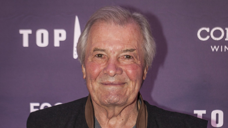 Jacques Pépin smiling in gray shirt and black vest