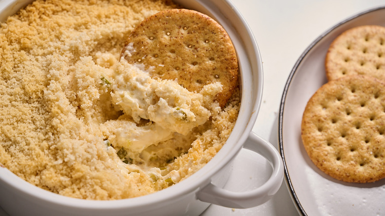 cracker in a dish with jalapeno popper dip