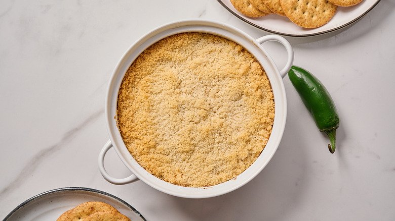 jalapeno popper dip on a table with crackers