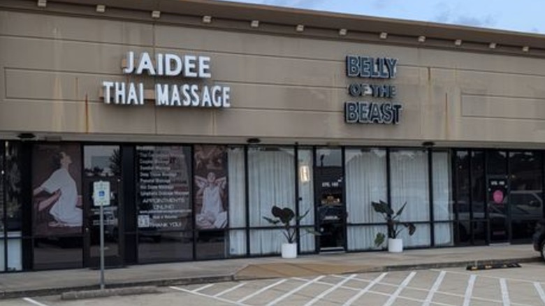 Strip mall with Belly of the Beast and Thai massage storefronts