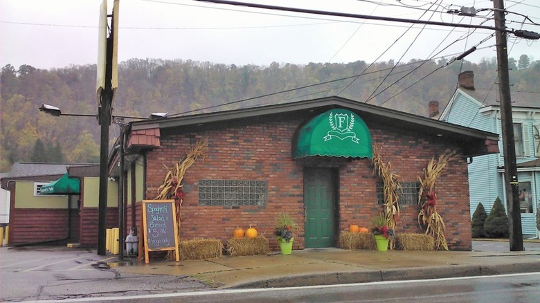 Brick building with green awning on a rainy day