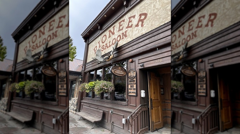 Exterior of the Pioneer Saloon with hanging baskets and antlers