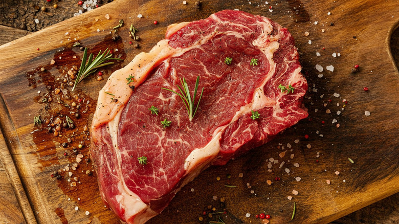 steak with seasoning on a cutting board