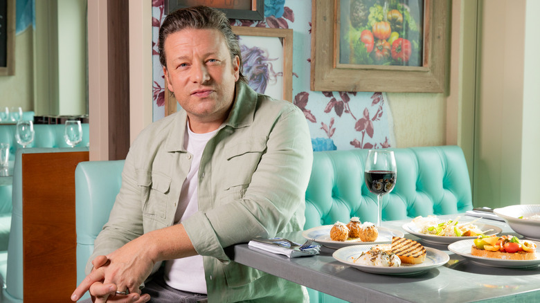 Jamie Oliver sitting at a booth