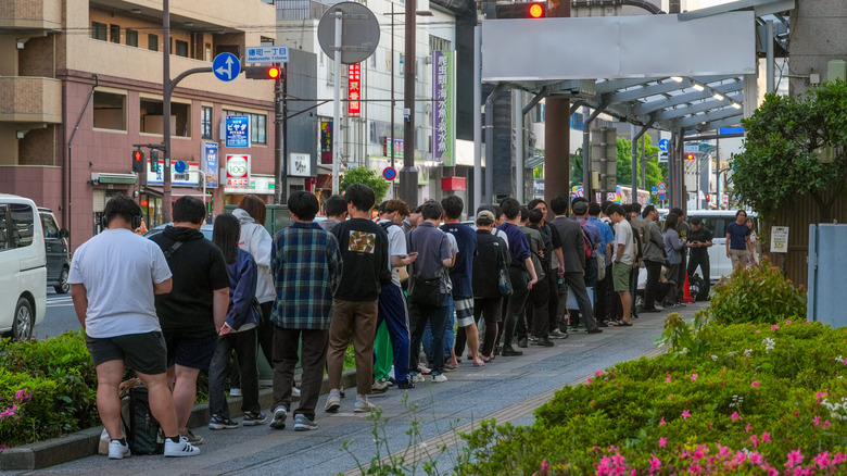 A long line of people queuing outside a restaurant in Yokohama