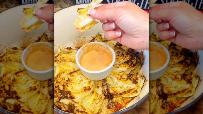 Person eating cabbage with dipping sauce