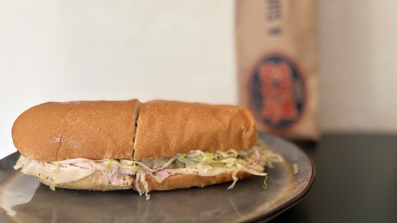 A close-up of a sub sandwich with paper bag