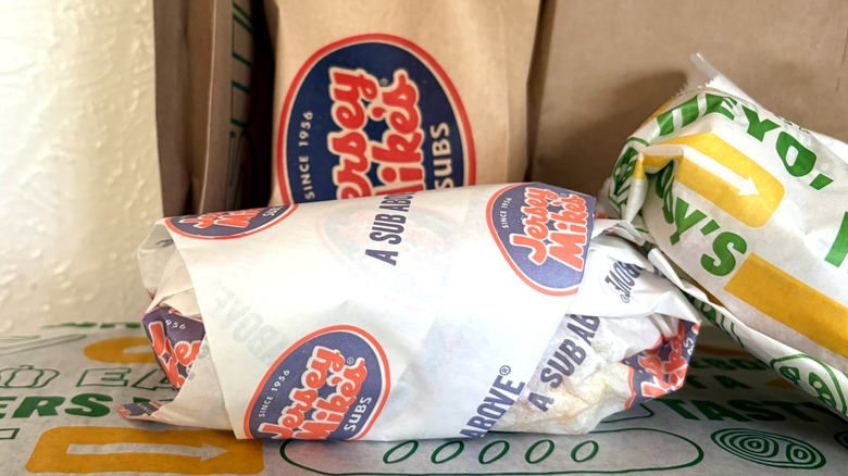 Close-up of wrapped club sub sandwiches on display