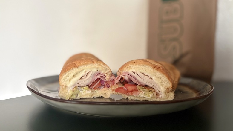 Sub sandwich on plate with bag in background