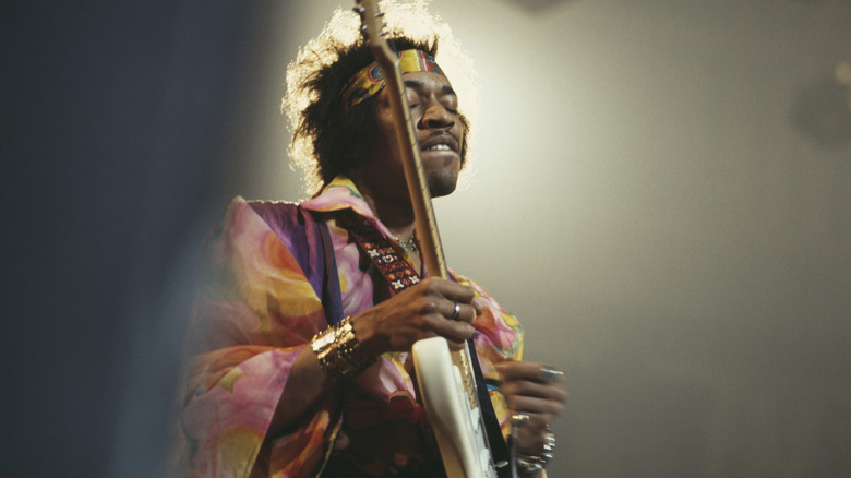 Jimi Hendrix playing guitar on stage