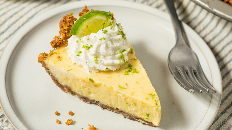 Key lime pie on a white plate with a fork