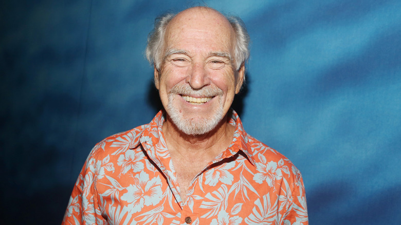 Jimmy Buffett smiling in orange floral printed shirt