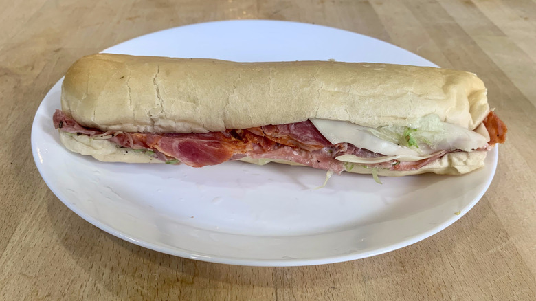 Jimmy John's italian sub unwrapped on white plate with wood background