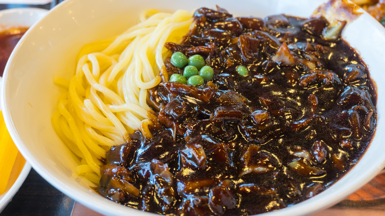 a bowl of jjajangmyeon with peas