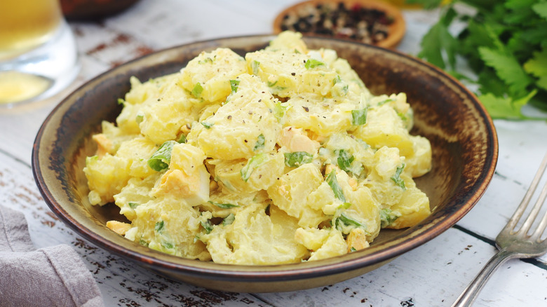 Potato salad in a bowl with greens