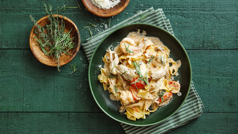 Seafood pasta dish, grated cheese, herbs on plate
