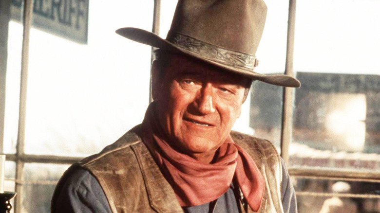 John Wayne wearing a cowboy hat and red neckerchief.