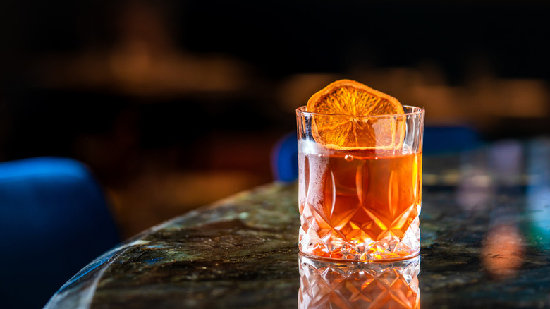 A cocktail served in a short glass with an orange peel