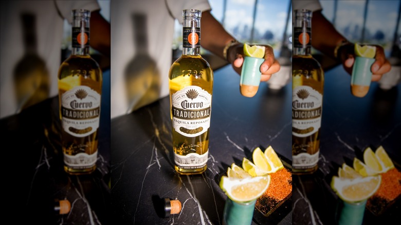 Jose Cuervo reposado on bar with person holding shot
