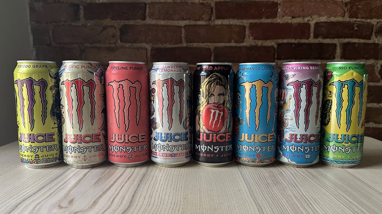 Juice Monster cans arranged in a line on wooden table