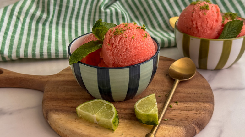 Bowl of watermelon sorbet with lime wedges