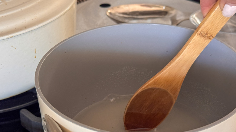 hand stirring simple syrup in pot