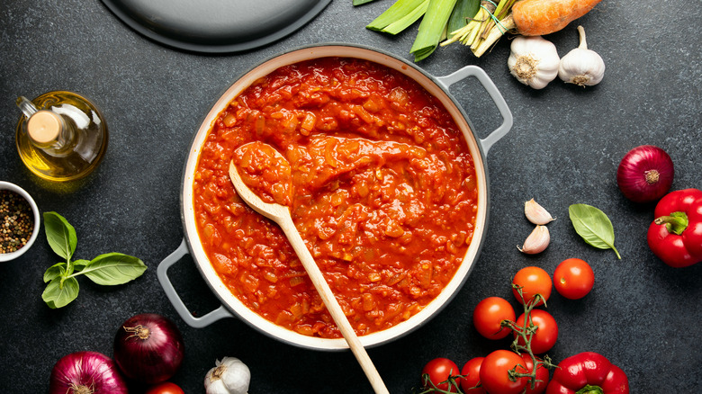 Pot of tomato sauce with wooden spoon inside