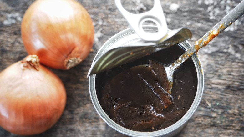 A can of French onion soup with two raw yellow onions