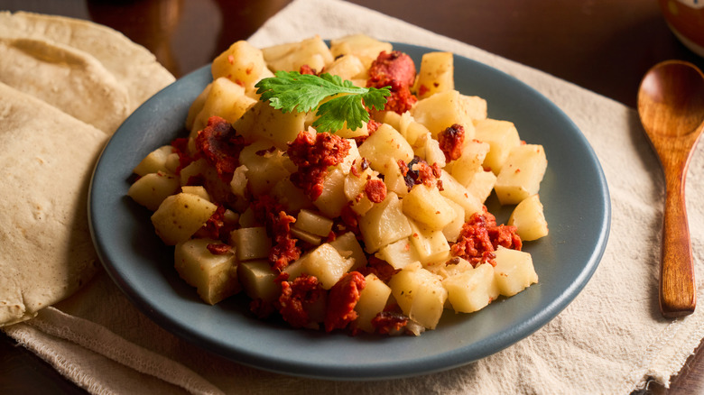 Potatoes with chorizo on a dish with tortillas