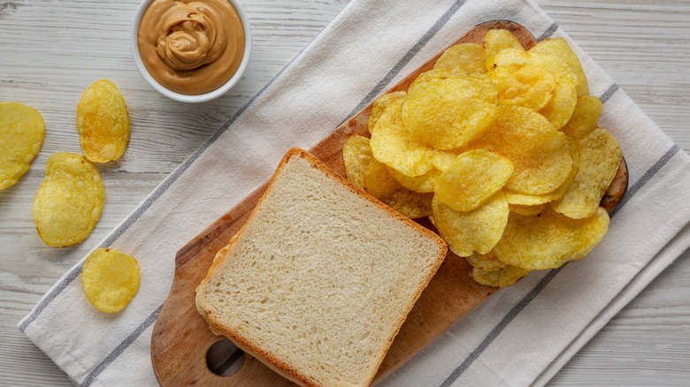 bread, potato chips, and peanut butter laid out on a table top