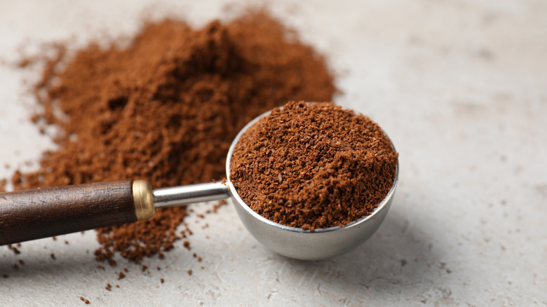 A scoop overflowing with loose espresso powder