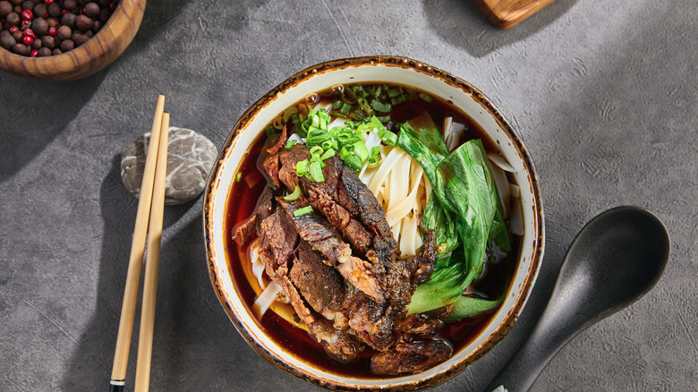 Overhead view of brisket ramen in bowl next to utensils