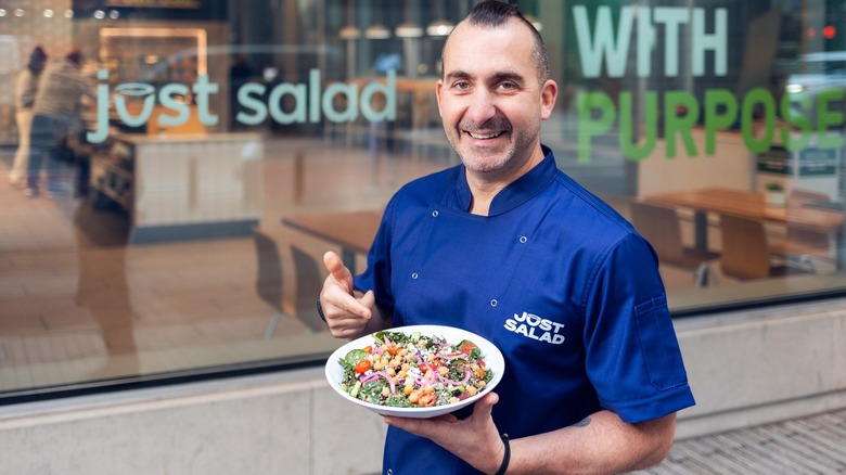 Marc Forgione holding a salad in front of Just Salad