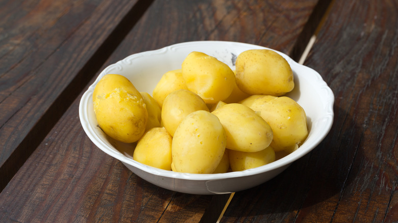 Bowl of boiled potatoes on a table.