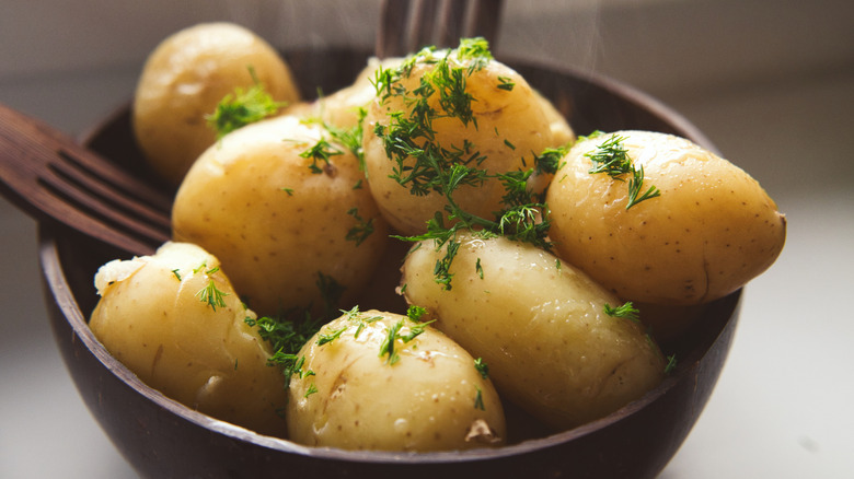 Bowl of boiled potatoes with parsley.
