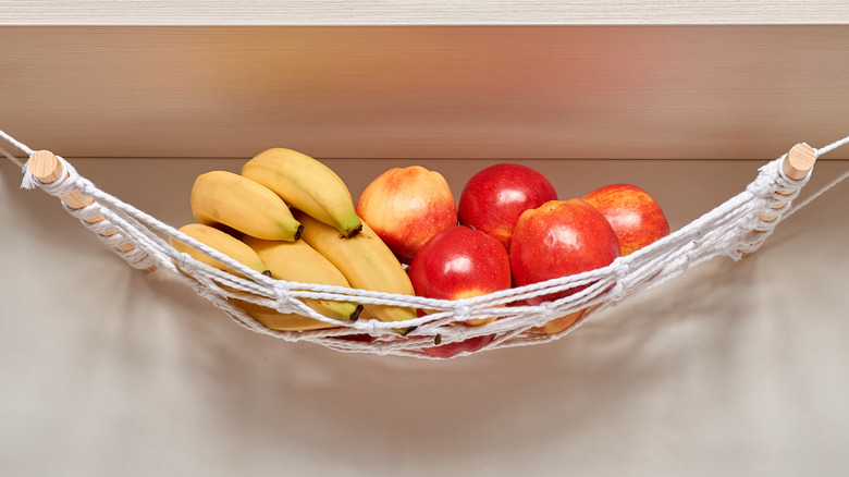Apples and bananas hanging in macrame fruit hammock