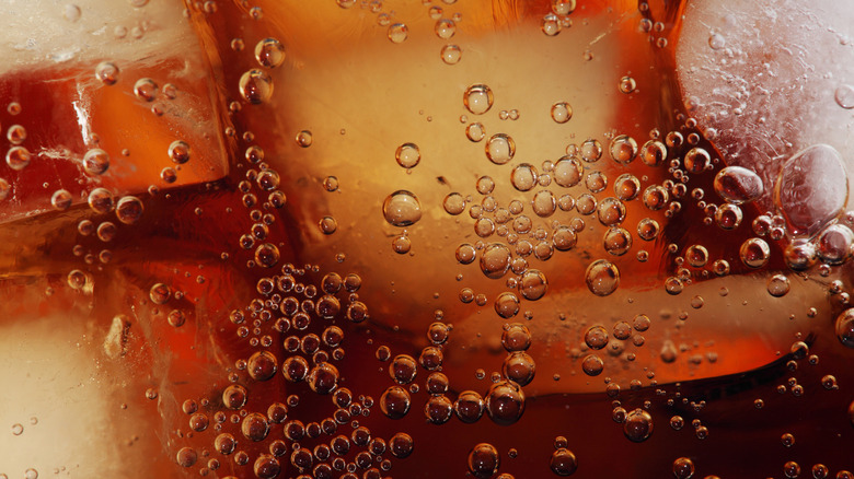 tiny bubbles forming in soda with ice