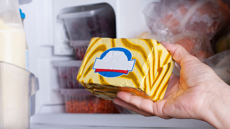hand placing butter in freezer