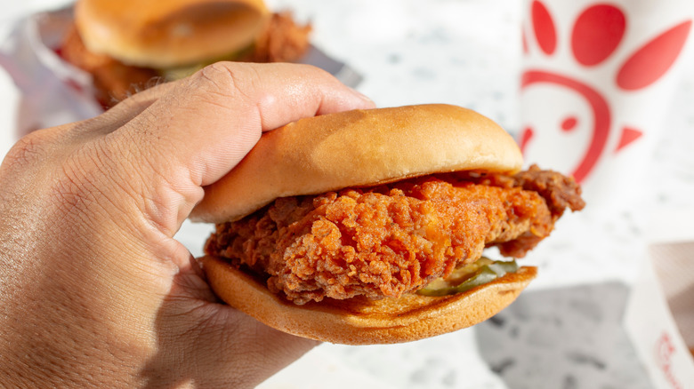 Hand holding Chick-fil-A chicken sandwich