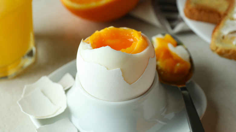Soft-boiled egg in cup with spoon