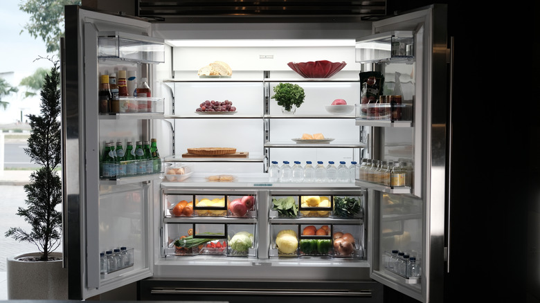 An open double-door fridge with food inside