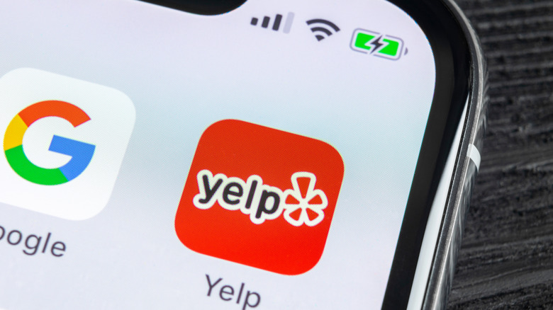 A mobile phone showing a Yelp and Google app