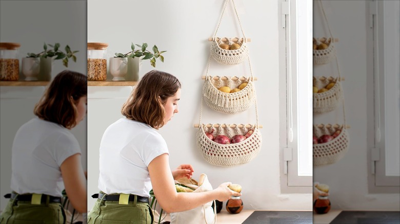 Girl standing next to 3-tier hanging fruit basket