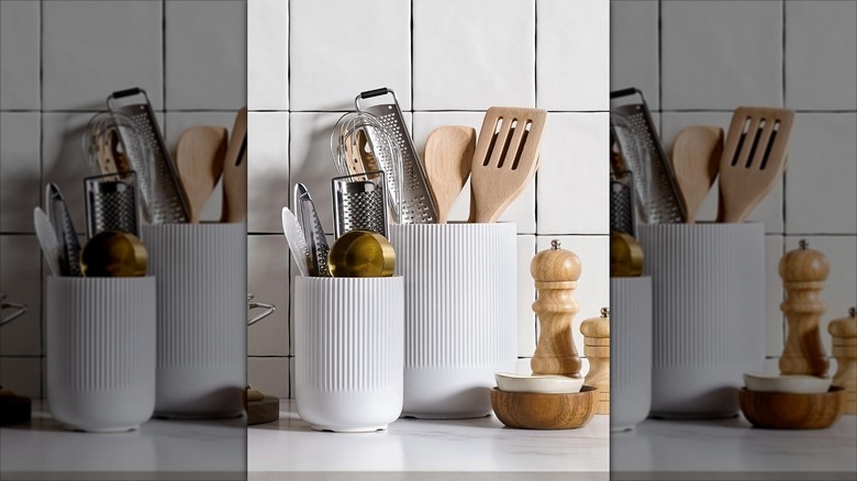 Two white ceramic utensil holders on white countertop