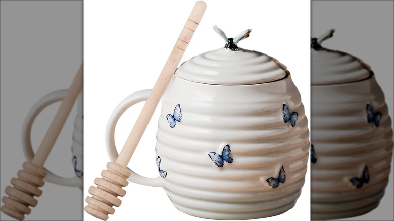 White ceramic honey jar with dipper decorated with blue butterflies