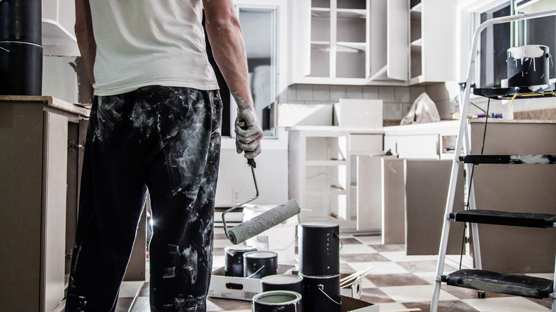 A person painting in the kitchen